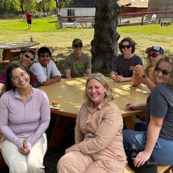 The Harvest Pack team gathered around a picnic table at the sanctuary