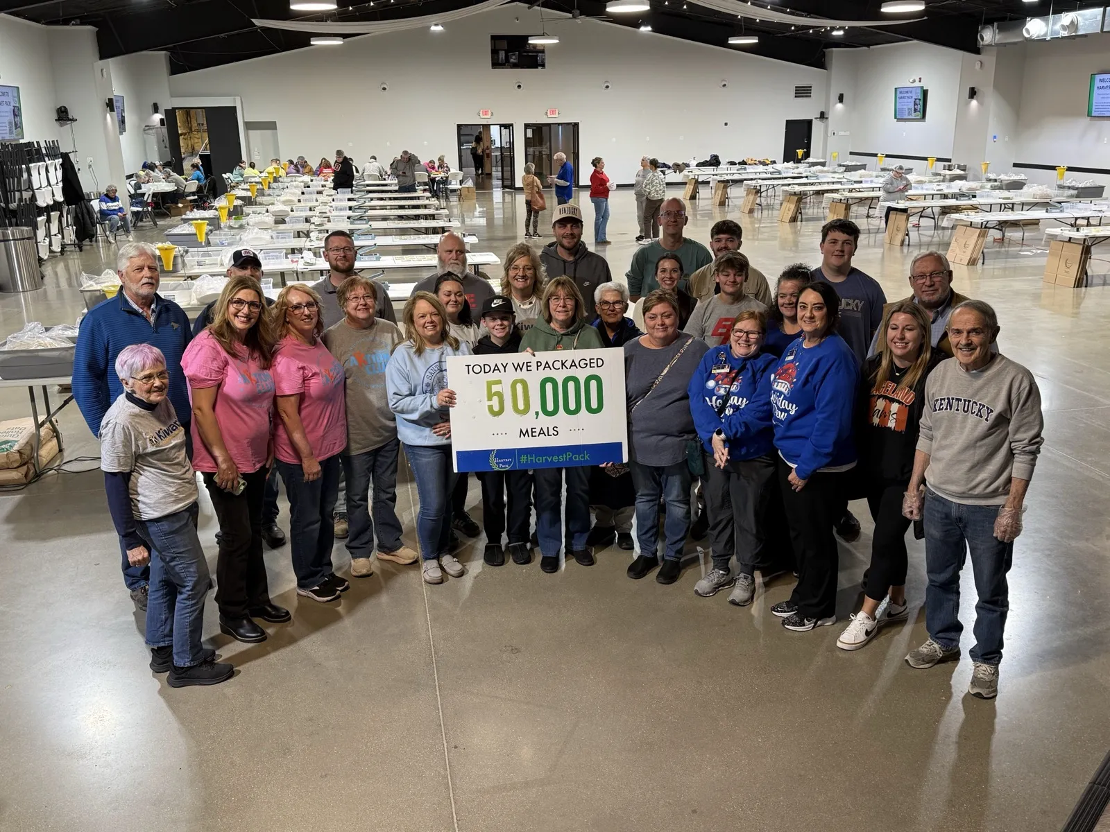 A large group of Harvest Pack volunteers celebrating at a packing event